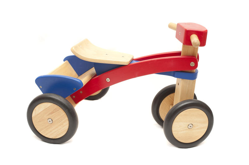 Colorful simple handmade wooden toy tricycle isolated on a white background