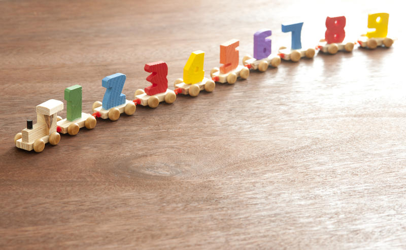 Educational wooden toy train with colorful numbers for counting mounted on small carriages to teach basic arithmetic