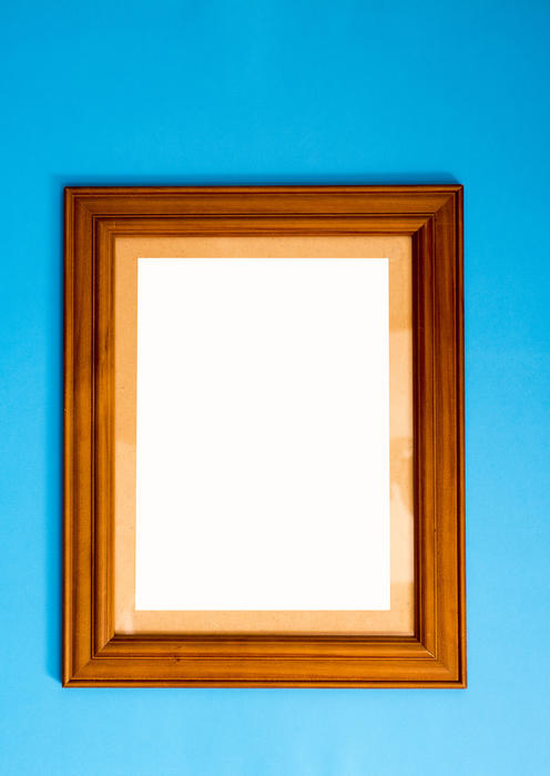 Blank empty rectangular wooden picture frame on blue for your artwork or photo