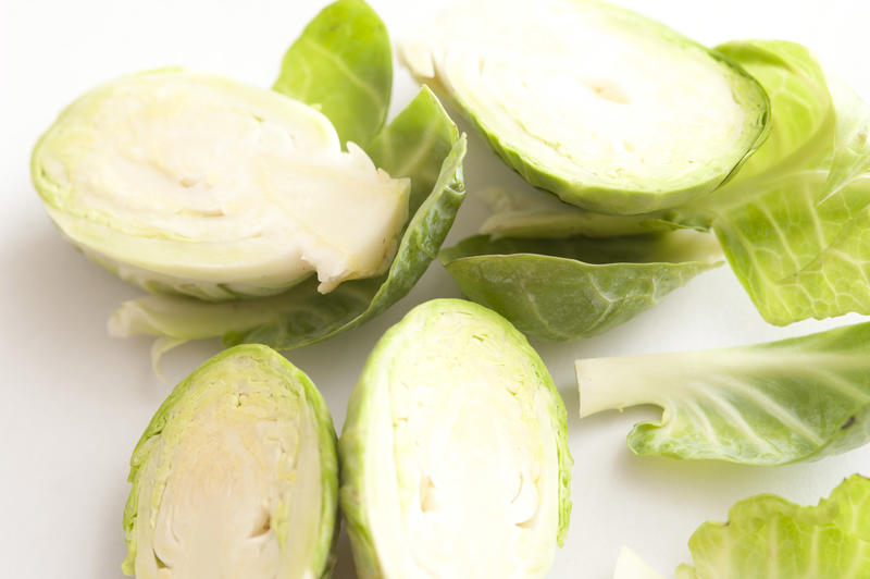 Close up detail of sliced fresh Brussel sprouts cut in half over a white background