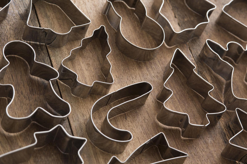 Christmas metal biscuit or cookie cutters arranged on a wooden table for a full frame holiday background