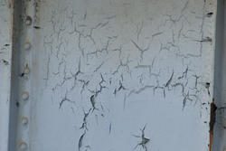 17757   Old peeling cracked white paint on metal panel
