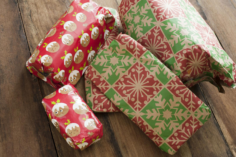 Colourful wrapped Christmas gifts on a rustic wood background viewed close up high angle to celebrate the holiday season
