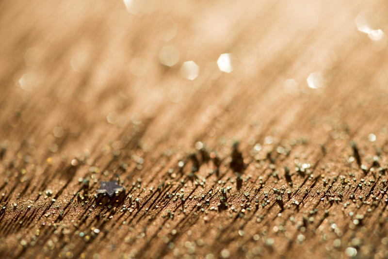 A close up abstract shot of a textured wood surface and warm background light.