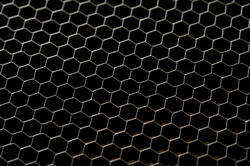 17768   Chicken wire mesh fence over a black background